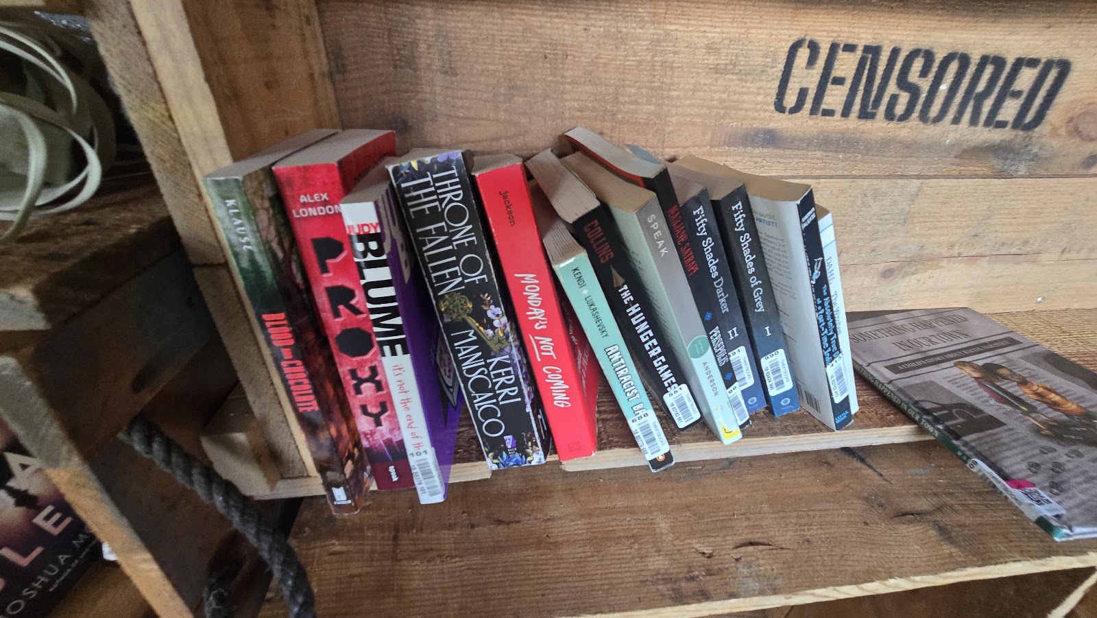 A shelf of banned titles under the carved word CENSORED